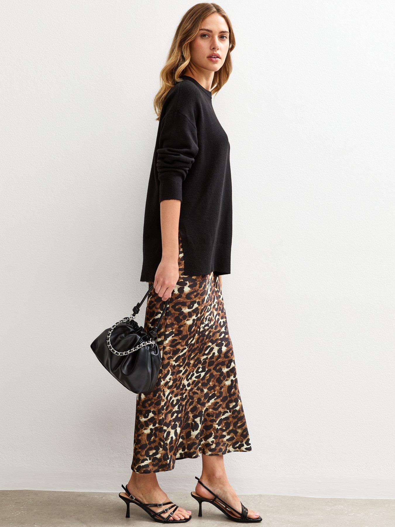 Woman in leopard print midi skirt with black sweater